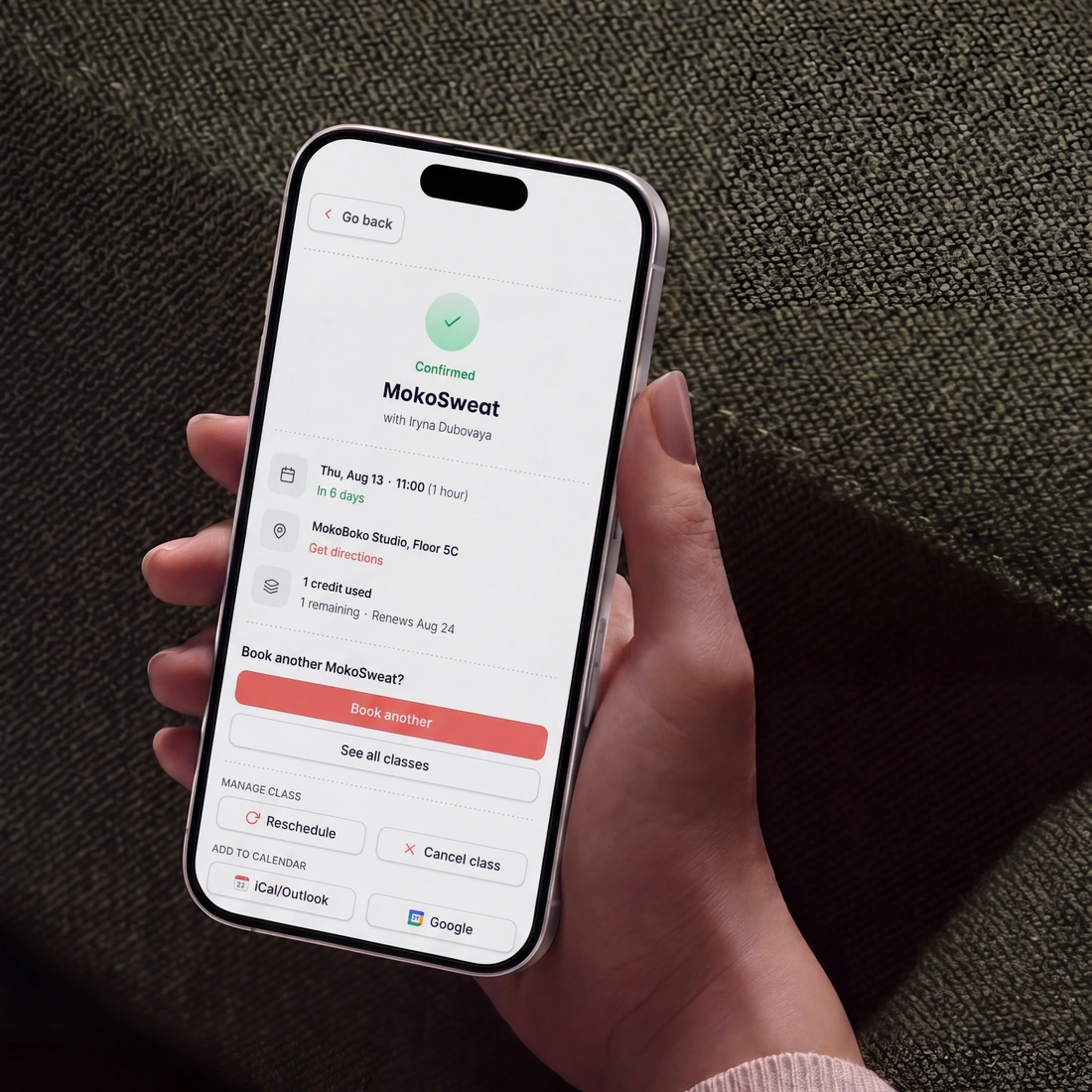 A confirmed booking on a customer’s phone, showing the class and its instructor, the day and time, the studio, the credit it used, and buttons to reschedule or cancel it.